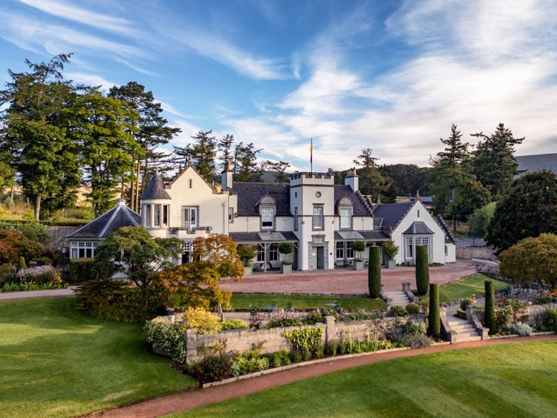Front exterior of Douneside House beneath a blue sky