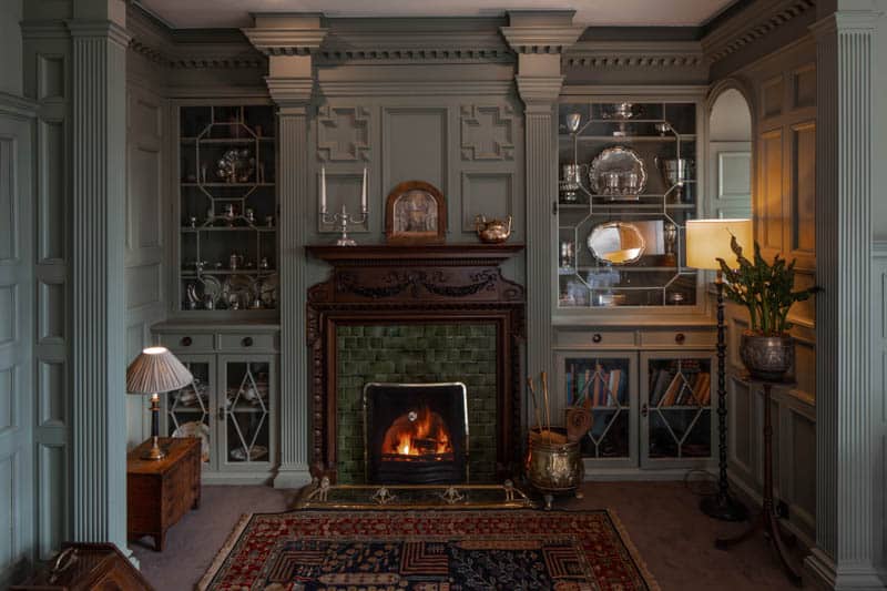 Fireplace in The Library Restaurant Lit fireplace surrounded by bookshelves in The Library at Douneside House