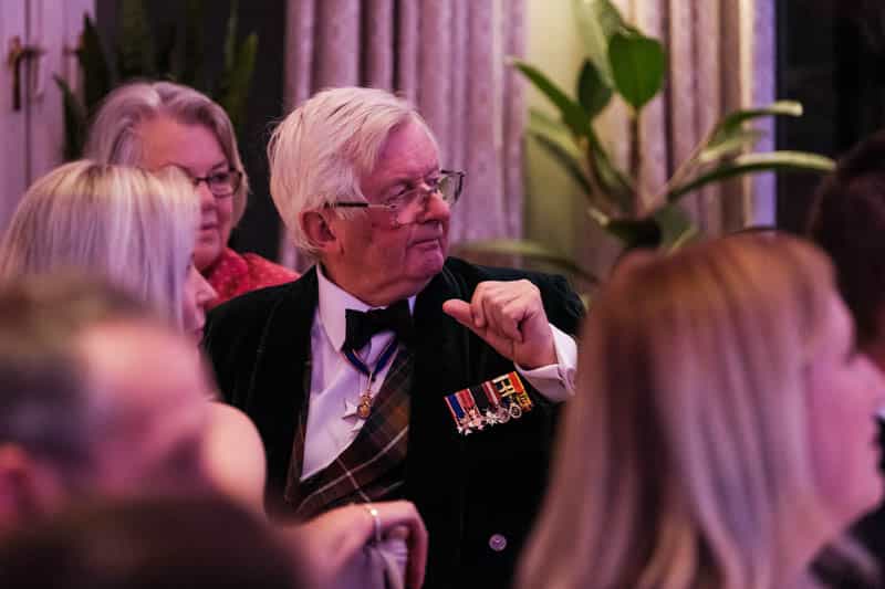 Military guest wearing medals during an event at Douneside House