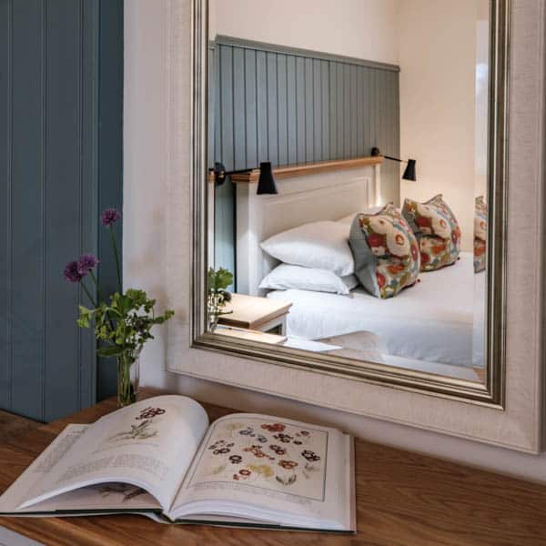 Bedroom with decorative cushions in the ground-floor Casa 23 apartment