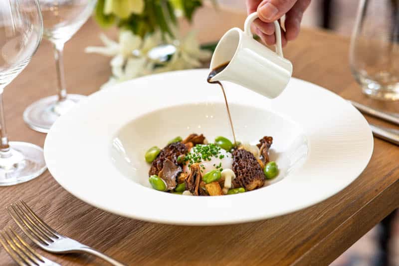 Sauce being poured over a seasonal dish at Douneside House