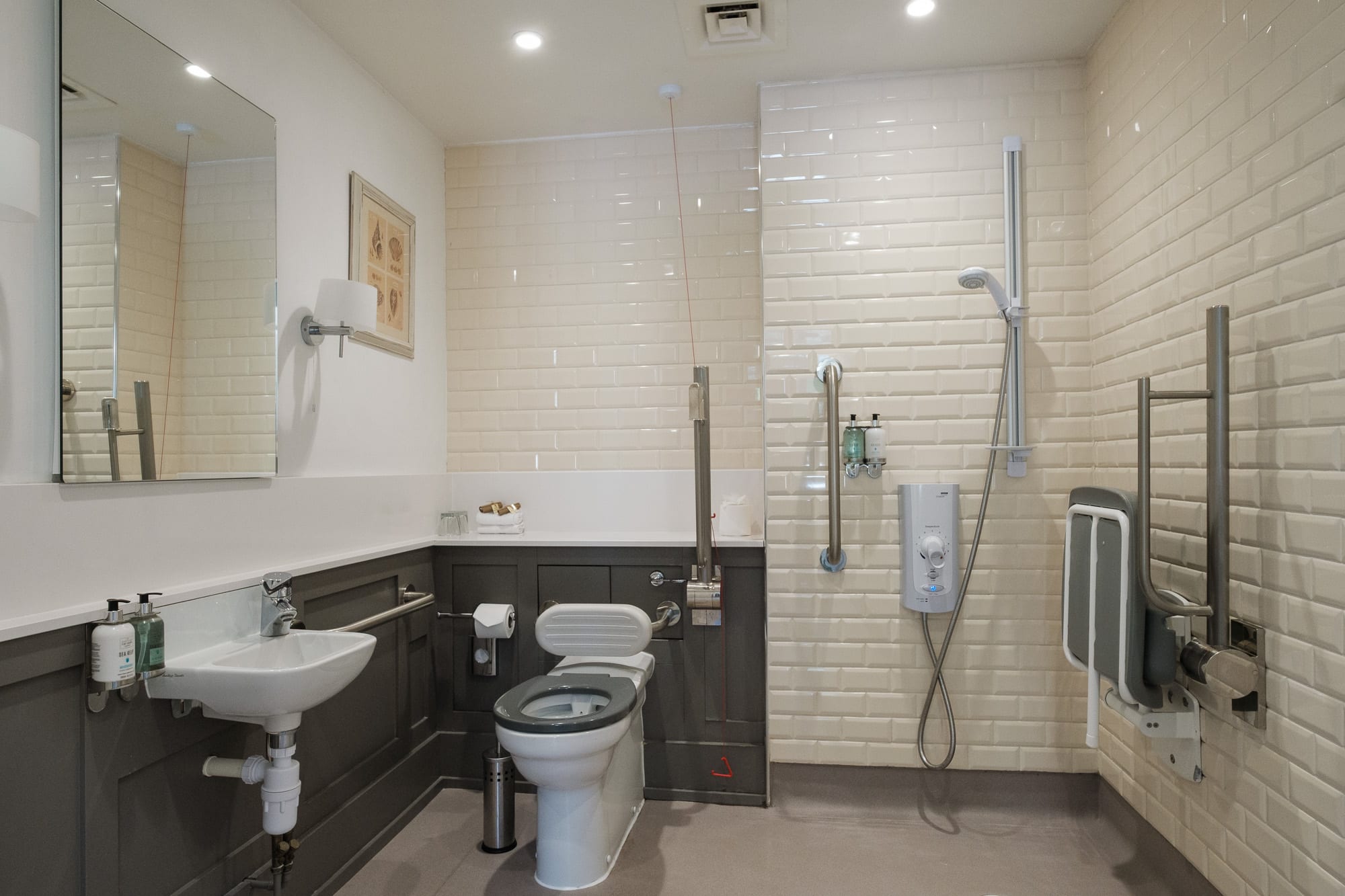 Accessible bathroom in Morven Cottage with walk-in shower, grab rails and shower seat at Douneside House