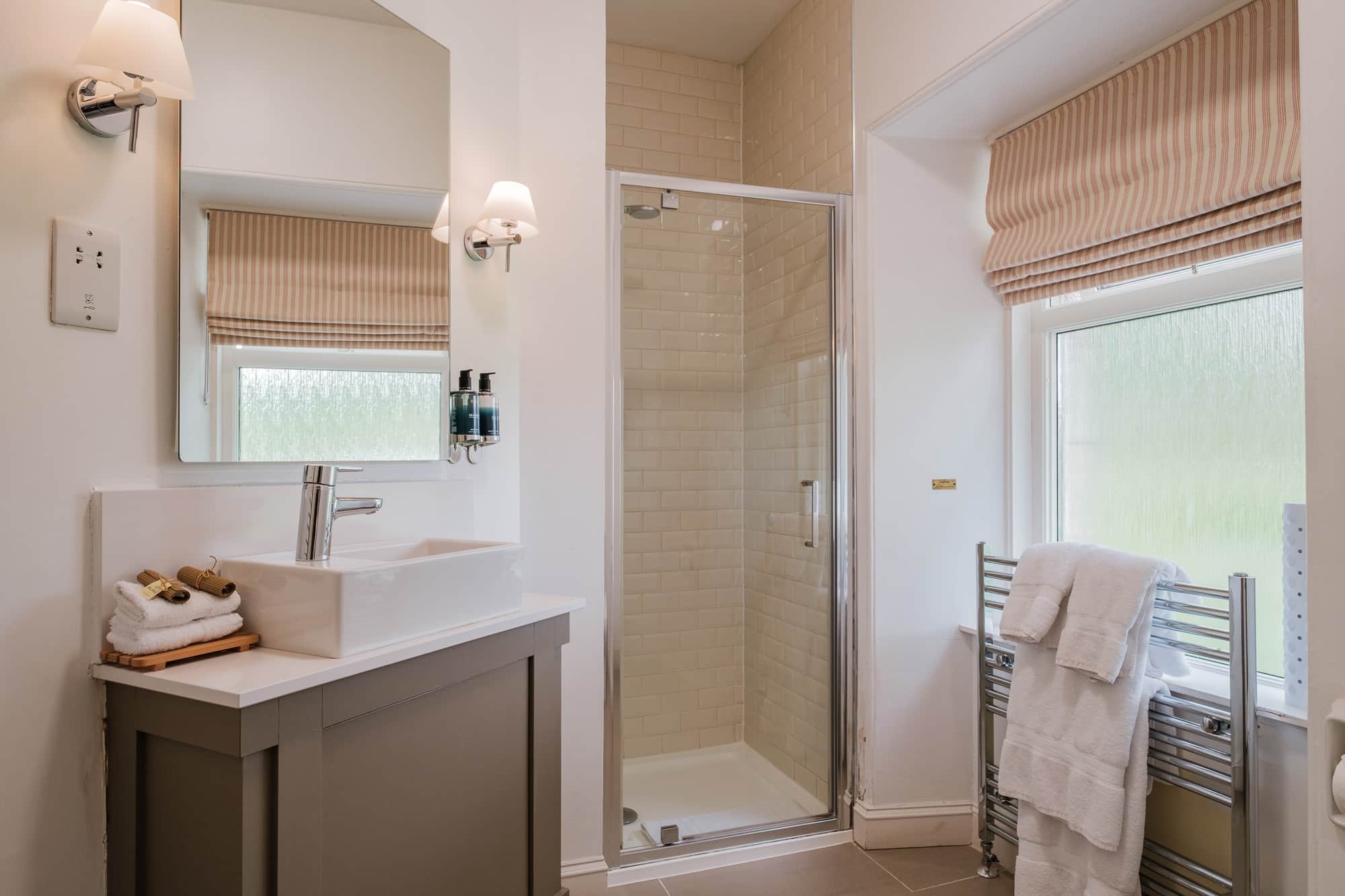 Twin bedroom in Gatehouse with ensuite bathroom, botanical wallpaper and reading lights at Douneside House