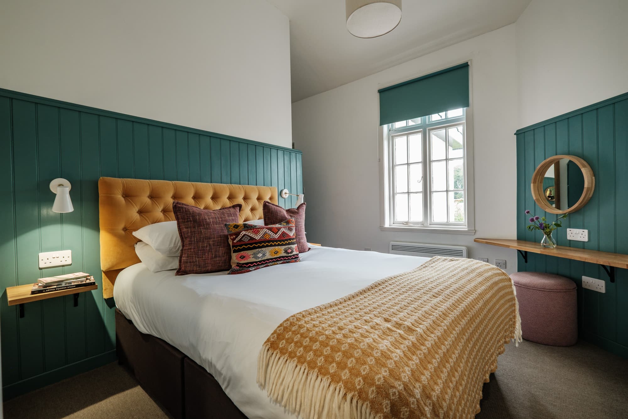 Bed_Detail_Dounebrae_Cottage Double bedroom in Dounebrae Cottage with mustard headboard, teal panelling and mustard throw at Douneside House