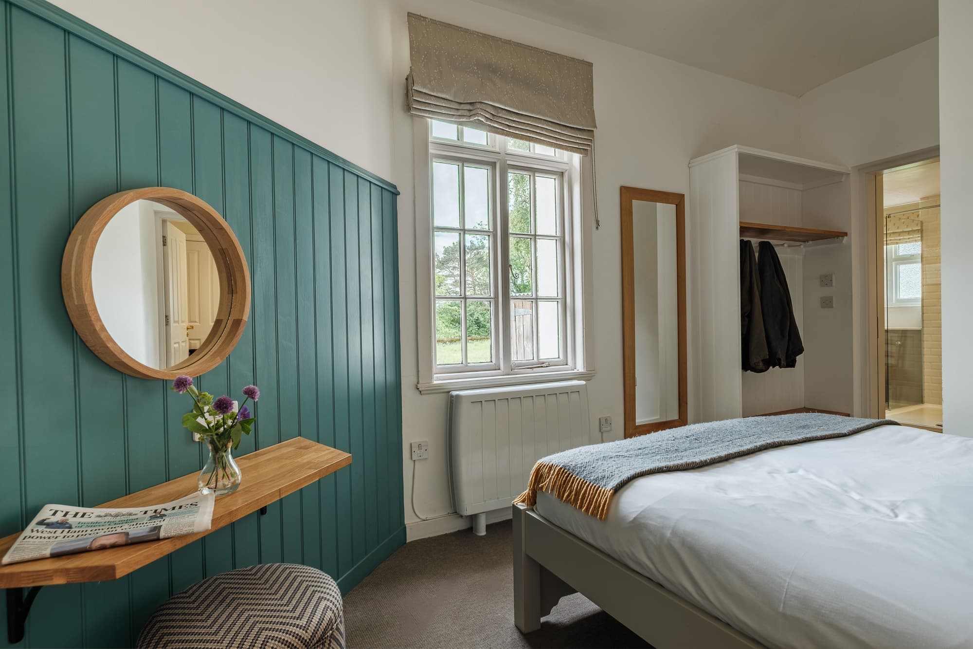Bedroom_Wardrobe_Dounebrae_Cottag Dounebrae Cottage bedroom with teal panelling, round mirror and open wardrobe at Douneside House