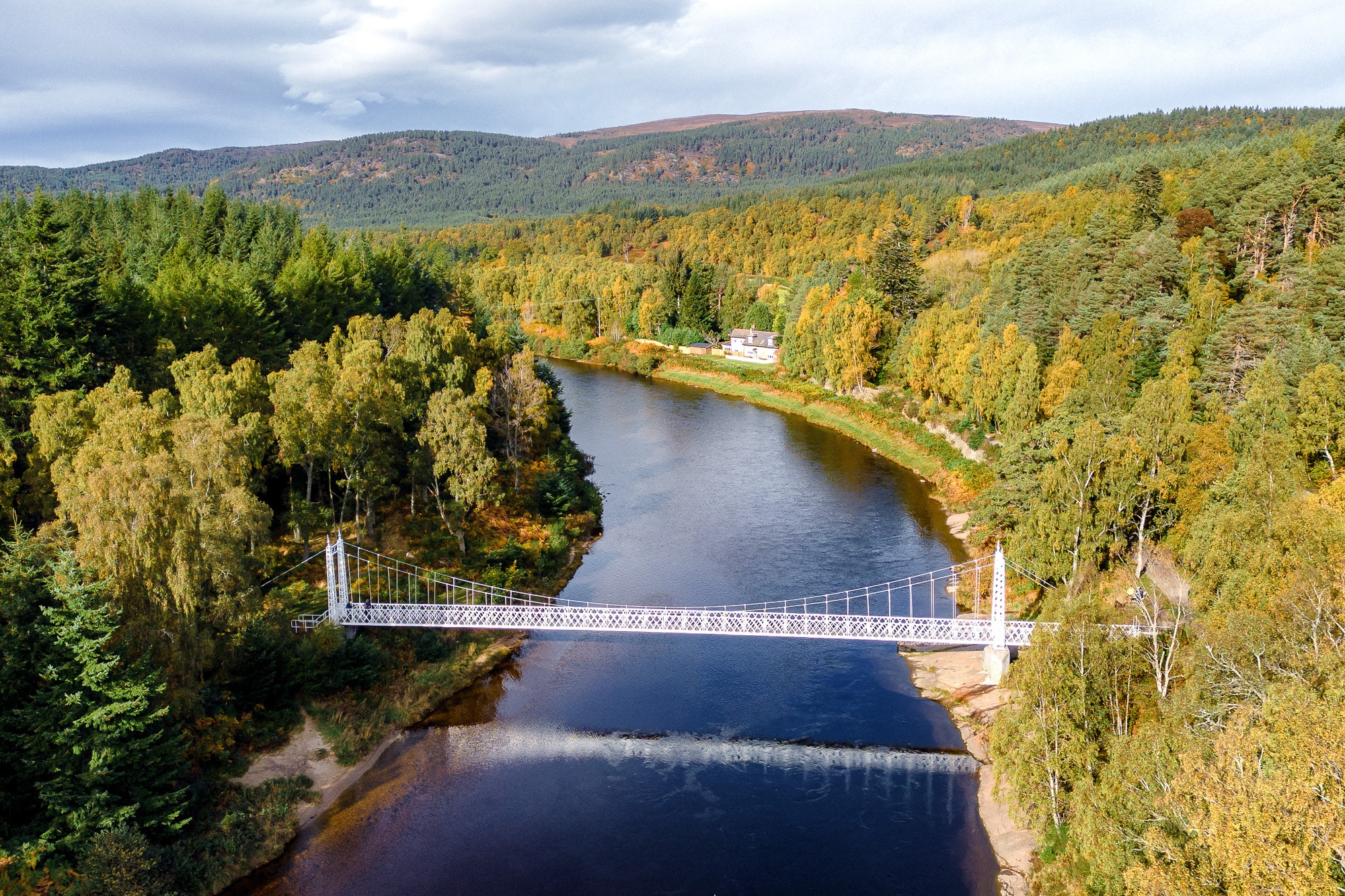 Cambus o May Bridge Aerial view of Cambus o' May Suspension Bridge crossing the River Dee in Royal Deeside, Aberdeenshire, surrounded by ancient woodland and the Cairngorms landscape.