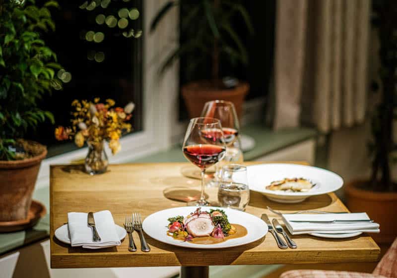Evening dining table with flowers, candles and wine at Douneside House, Conservatory Restaurant