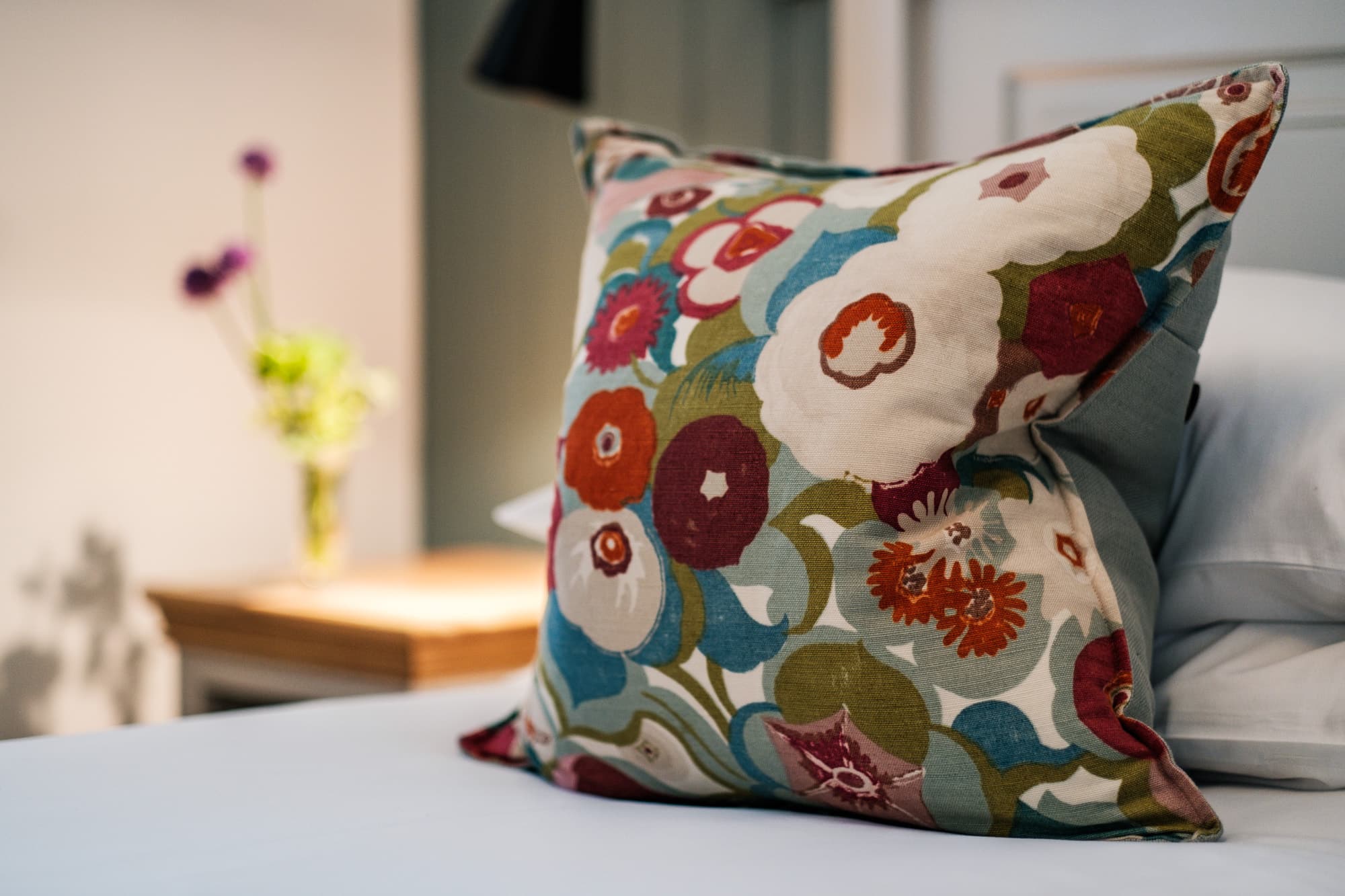 Casa 23 bedroom detail with vintage floral cushion and bedside wildflowers at Douneside House