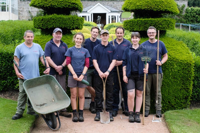 Douneside House gardening team standing outdoors with their garden tools