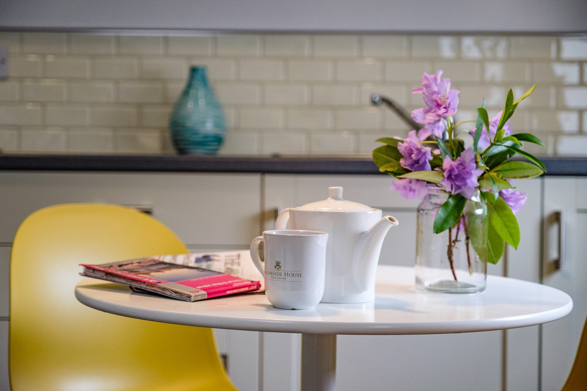 Casa 24 dining detail with branded Douneside House mug, teapot and wildflowers