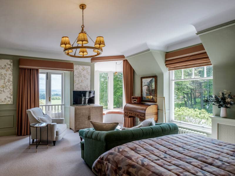 Separate sitting room with comfortable seating and garden doors in the Lady MacRobert Deluxe Room