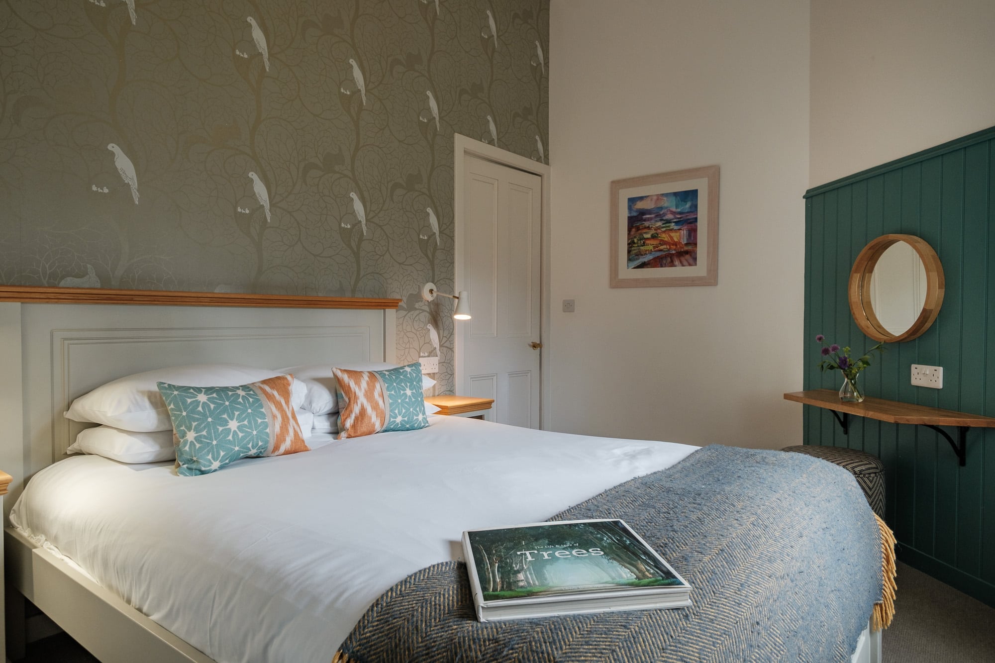Double_Bedroom_Dounebrae_Cottage Second bedroom in Dounebrae Cottage with bird-print wallpaper, teal dressing panel and landscape artwork at Douneside House