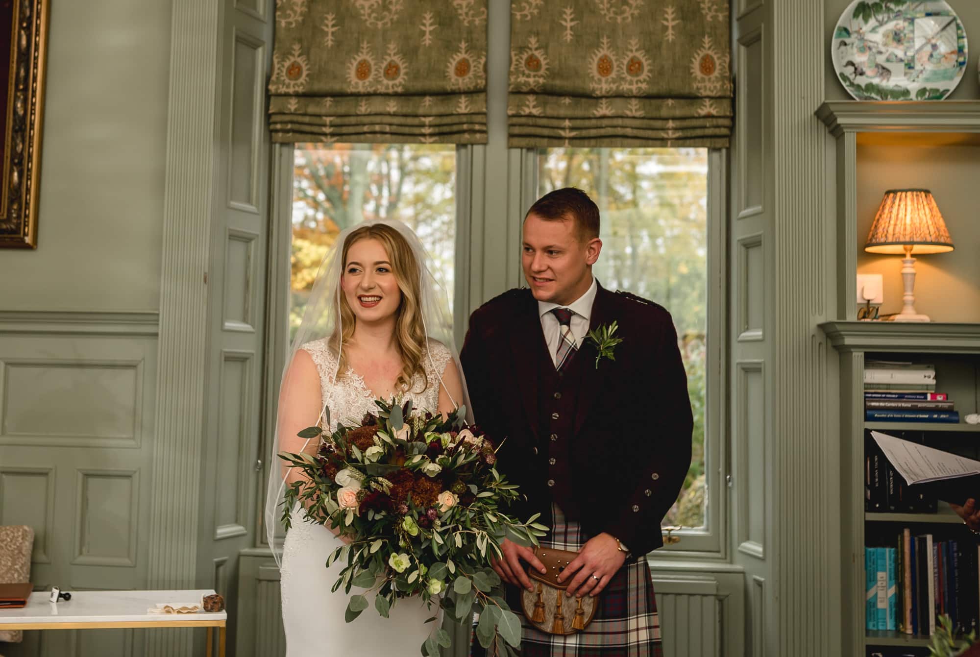 An elopement couple having their ceremony in the Library at Douneside house
