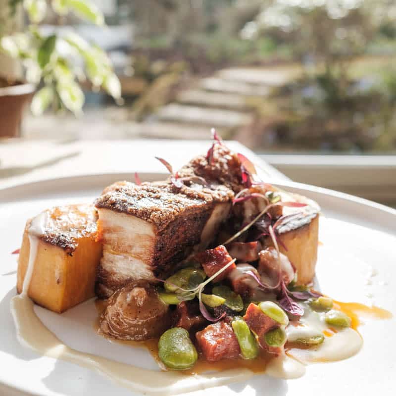 Pork belly served in the Douneside House Conservatory restaurant with garden windo view