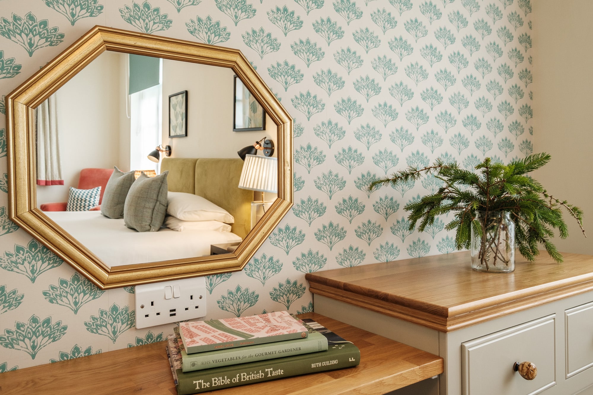 Morven Cottage dressing area with octagonal gold mirror, oak console and teal patterned wallpaper at Douneside House
