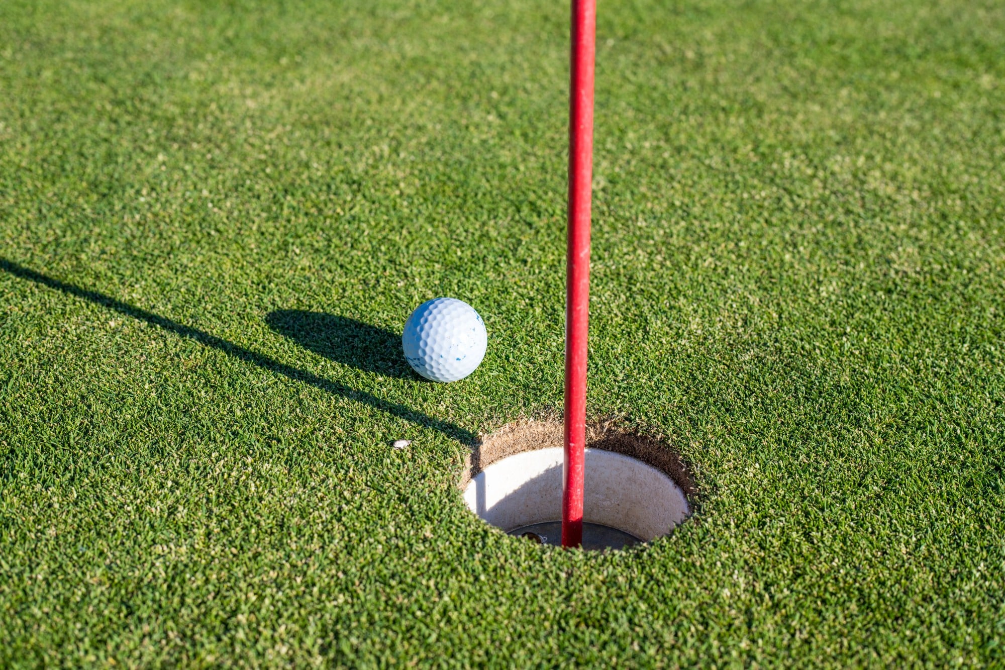 Golf in Deeside Golf ball sitting at hole