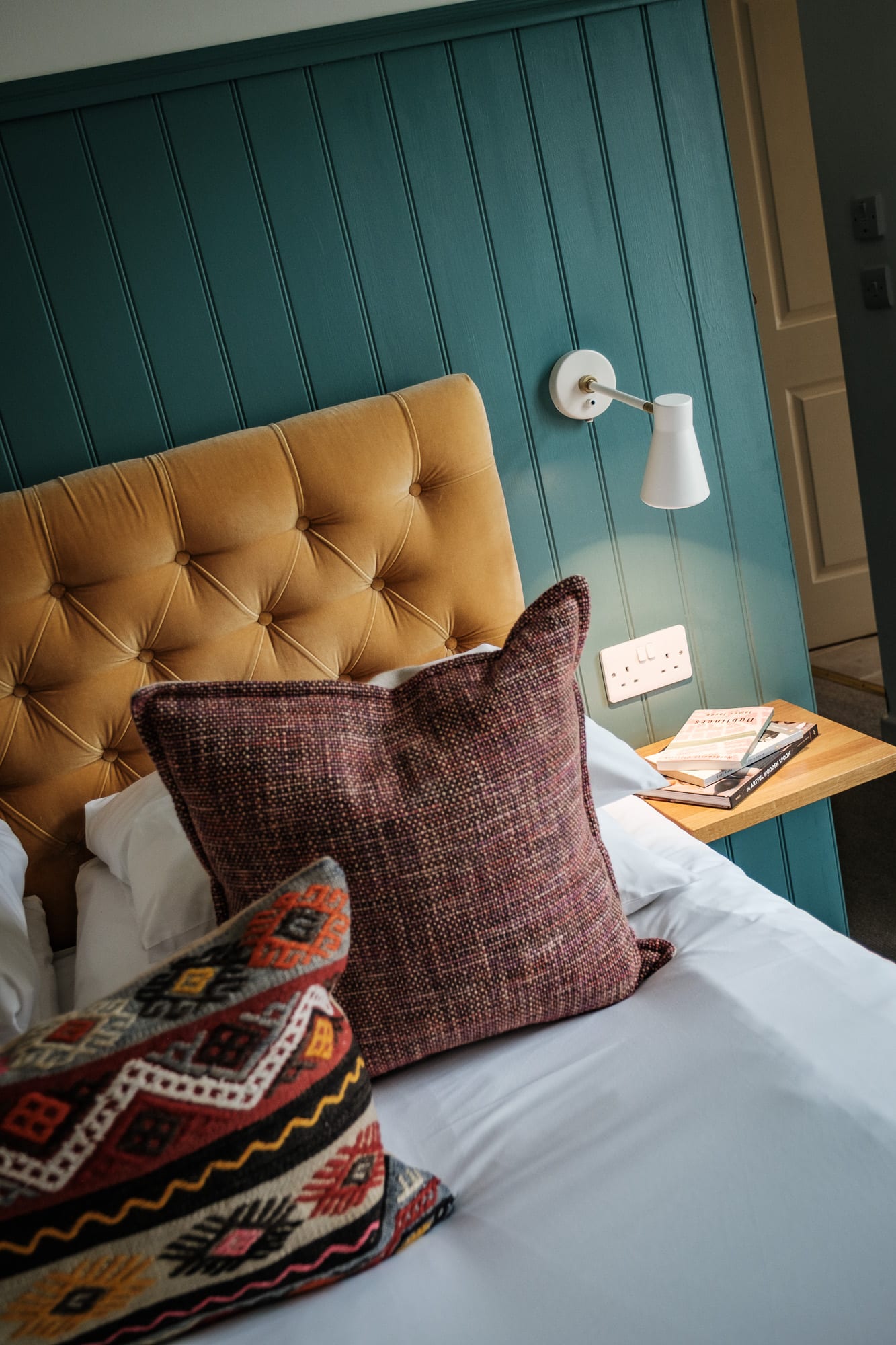 Headboard_Detail_2Dounebrae_Cottage Dounebrae Cottage bedroom detail with mustard buttoned headboard, kilim cushion and teal panelled wall at Douneside House
