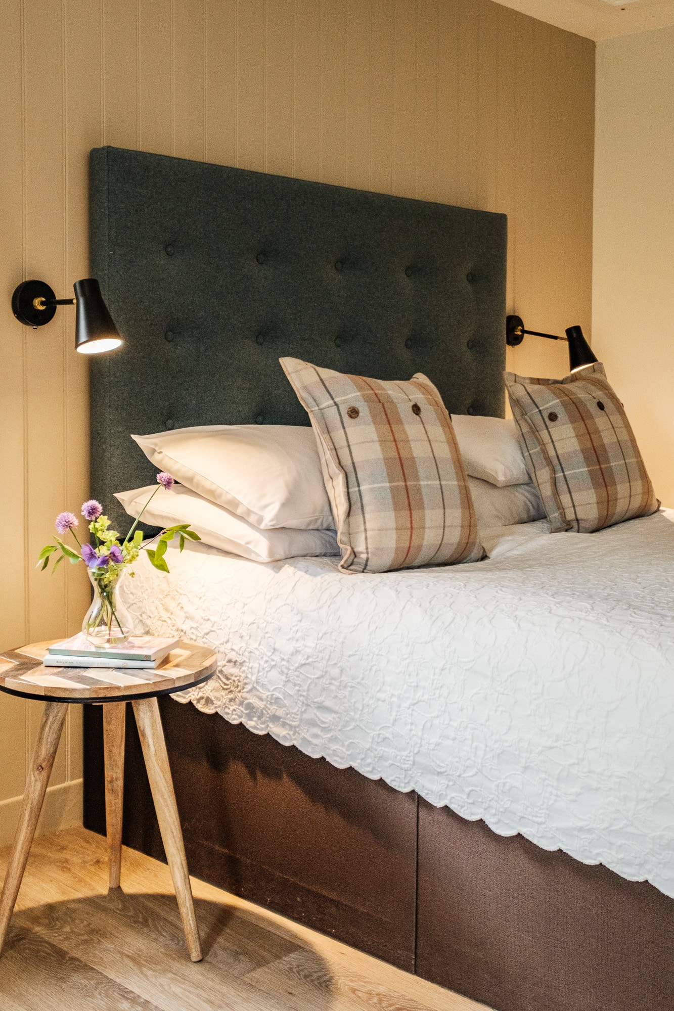 Casa 22 bedroom detail with tufted headboard, tartan cushions and reclaimed wood side table at Douneside House