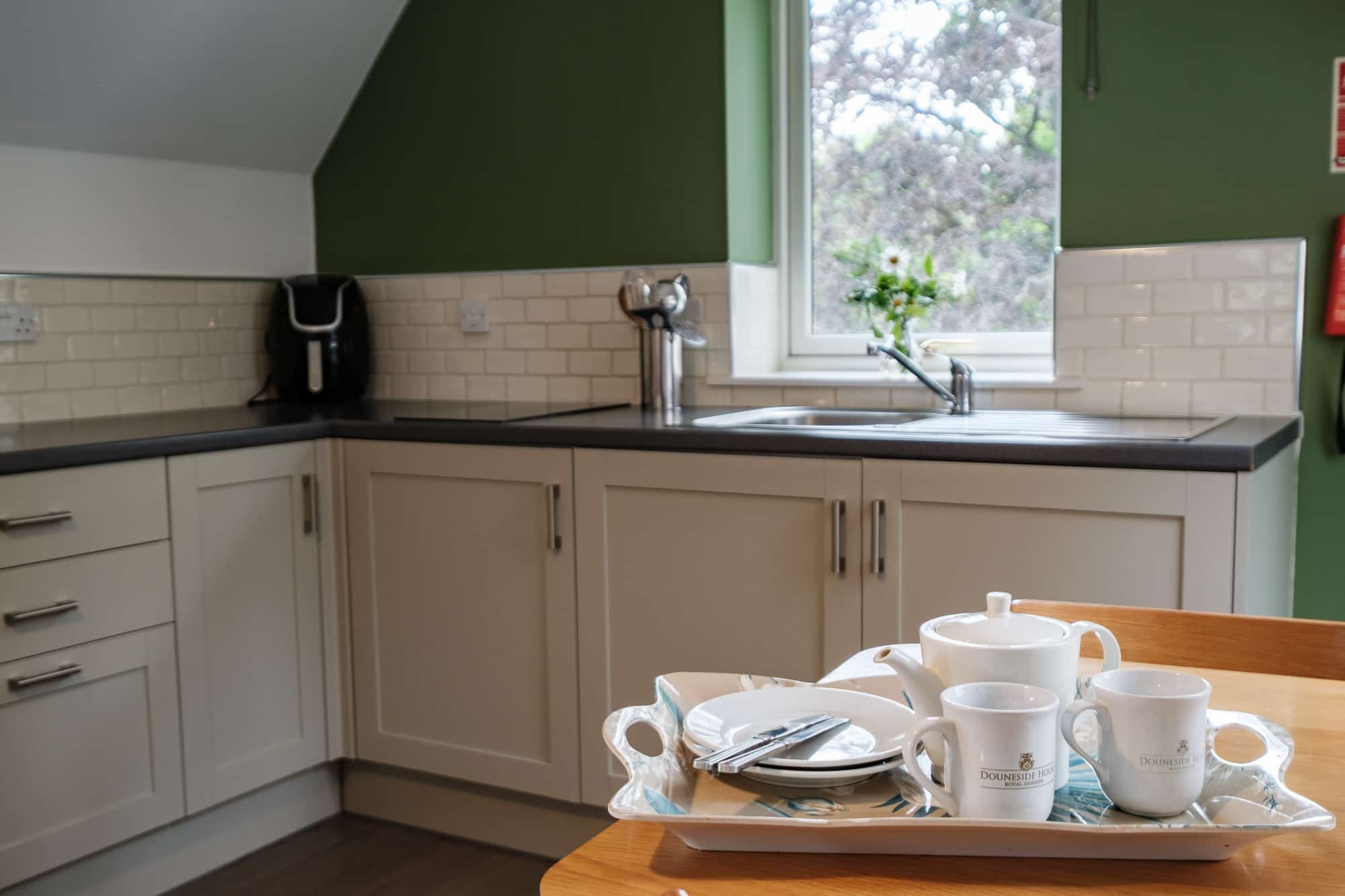 Kitchen_Casa_21 Kitchen in Casa 21 with green feature wall, subway tiles and branded Douneside House tea tray