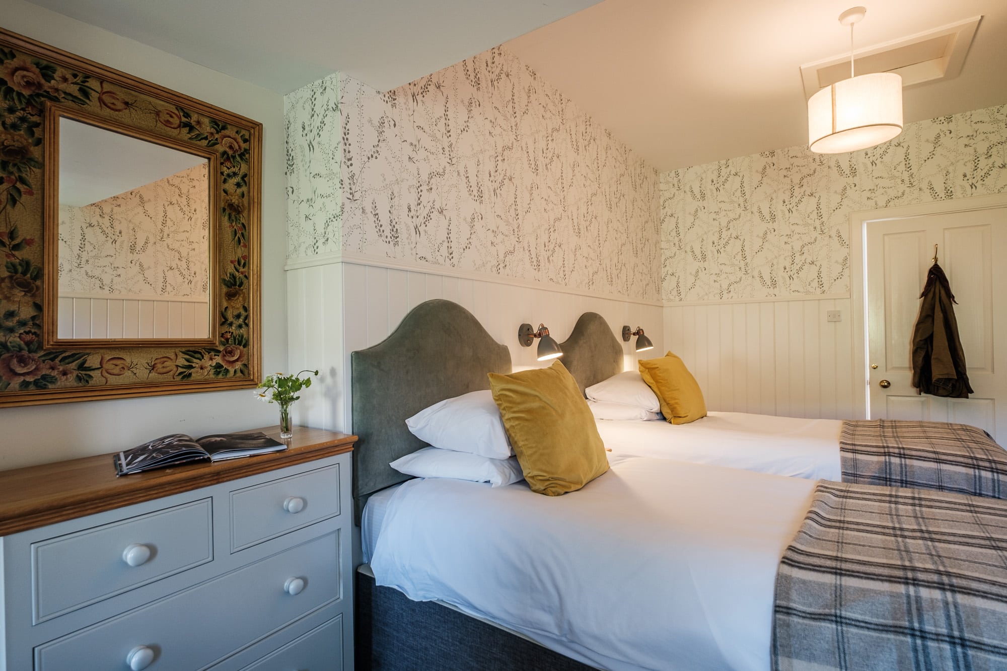 Pine Cottage twin bedroom with vintage floral mirror, mustard cushions and reading lights at Douneside House