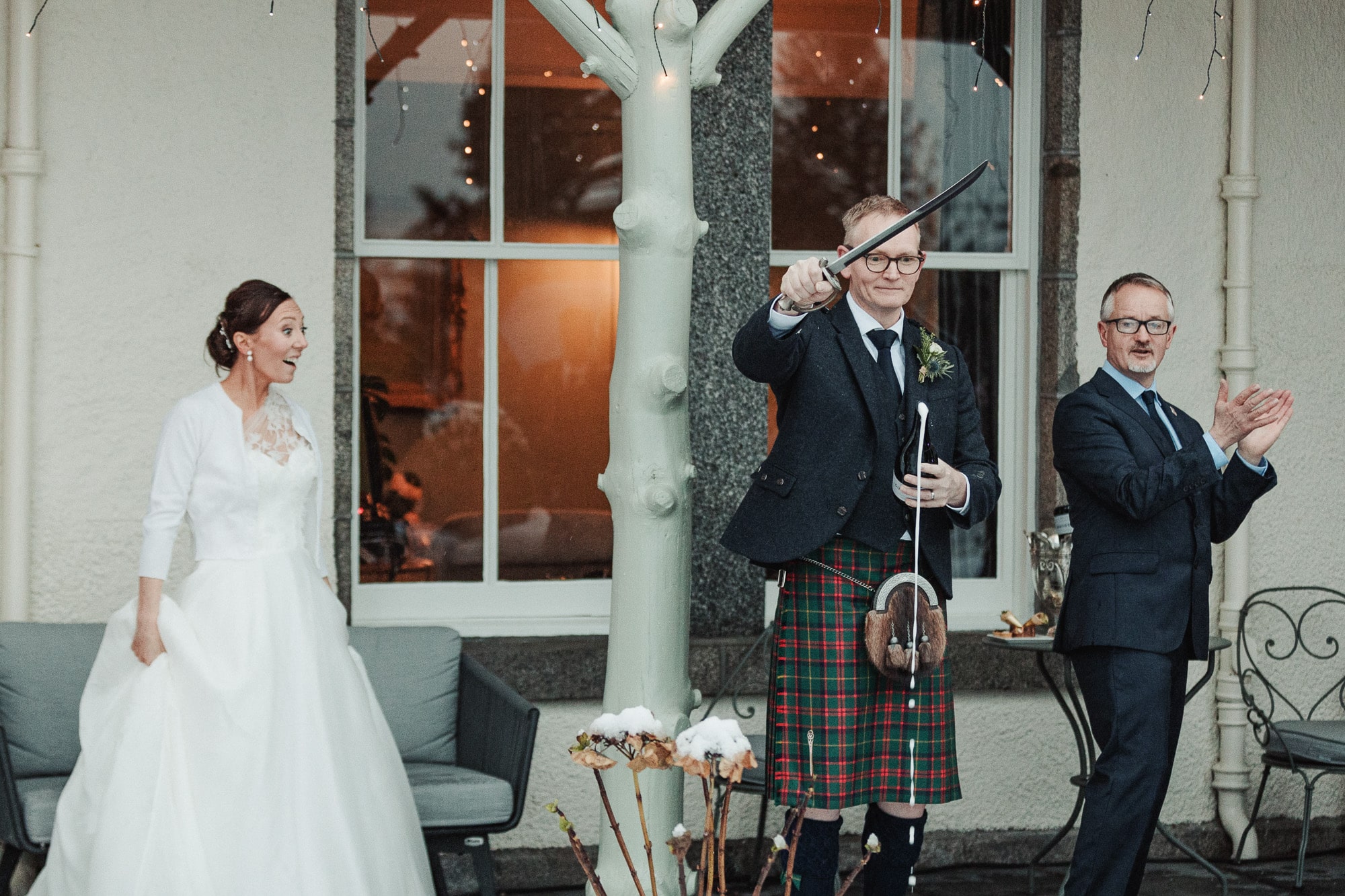 Opening Champagne with sword Bridegroom opening a bottle of champagne with a sword at Douneside House wedding