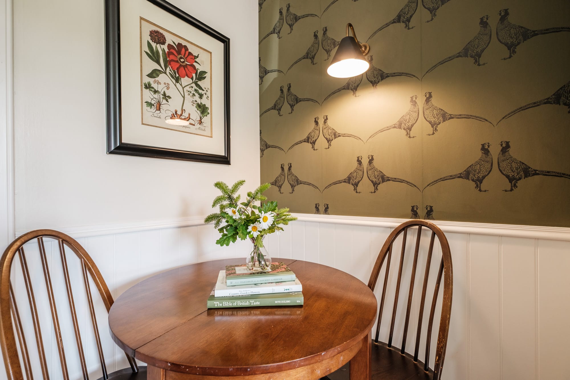 Pine Cottage dining nook with round wooden table and pheasant-print wallpaper at Douneside House