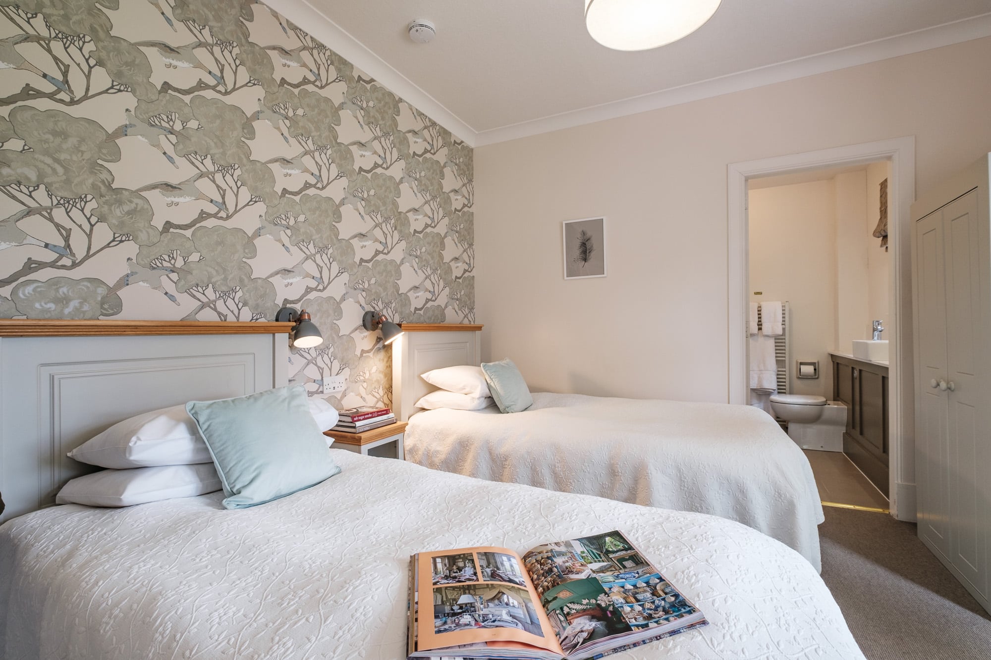 Twin bedroom in Gatehouse with ensuite bathroom, botanical wallpaper and reading lights at Douneside House