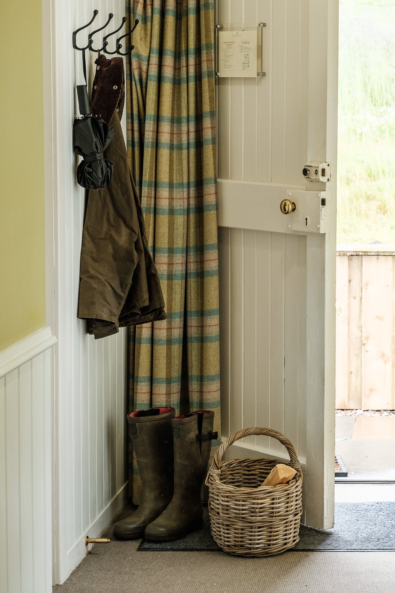 ntrance_Hall_Dounebrae_Cottage Entrance hall in Dounebrae Cottage with tartan curtain, country boots and log basket at Douneside House
